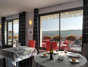 Chassey-le-Camp的住宿－羅曼營地酒店，餐厅设有两张桌子和一瓶葡萄酒