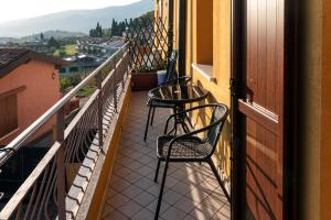einen Balkon mit 2 Stühlen und Stadtblick in der Unterkunft Casa Del Sole in Gavardo