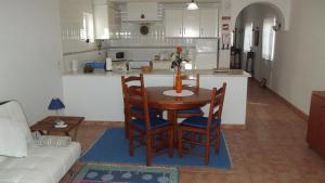 cocina y mesa y sillas en una habitación en Family Floripes House, en Olhão