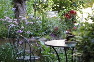 un tavolo e sedie in un giardino fiorito di Studios Garden Terrace Oltrarno a Firenze