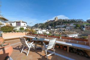 a patio with a table and chairs on a roof at Casa del Beso in Granada