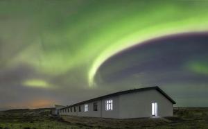 a building with the aurora in the sky at Hotel Gullfoss in Haukadalur