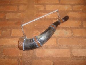 a brown horn on a brick floor with a string at Pousada Império estrada Real in Santa Cruz de Minas
