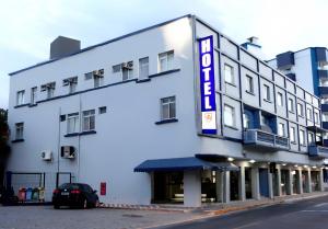 un bâtiment blanc avec un panneau indiquant l'hôtel dans l'établissement Hotel Vitoria - Itajaí, à Itajaí