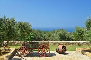 a cart and a barrel sitting on a stone path at Grecian Villas Chania in Delimanolianá