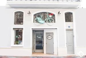 un edificio blanco con una bicicleta colgando de la puerta en Hotel Smile & Co Hostal Boutique en Alicante