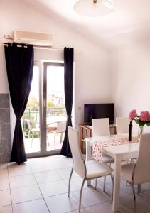 a dining room with a table and chairs and a window at Meri Apartment in Vodice