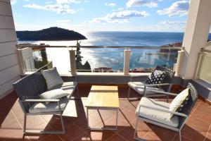 einen Balkon mit Stühlen, einem Tisch und Meerblick in der Unterkunft 87 Stairs Apartments in Dubrovnik