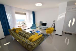 uma sala de estar com um sofá e cadeiras amarelas em 87 Stairs Apartments em Dubrovnik