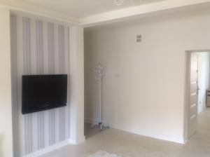 Una sala de estar con un televisor de pantalla plana en una pared. en Nordic Apartamenty Lipowa, en Białystok