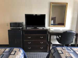 a hotel room with a television and a desk with a computer at Americas Best Value Inn Mount Vernon in Mount Vernon +2 photos