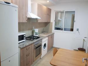 a kitchen with a stove top oven next to a microwave at Appartement S+1 Jardin De Carthage in Tunis