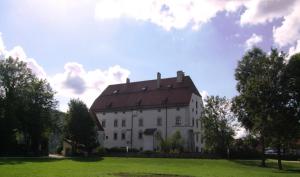 a large white building with a red roof at Ferienwohnung Örtl 7 in Obernzell