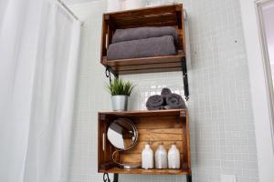 ein Badezimmer mit Holzregalen, Handtüchern und einem Spiegel in der Unterkunft Sea View Apartment in El Médano with pool & private parking space in El Médano