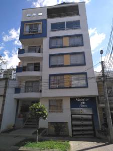 un edificio blanco alto con muchas ventanas en Habitar de Asis en Bucaramanga