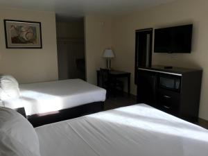 a hotel room with two beds and a flat screen tv at Colton Inn in Colton