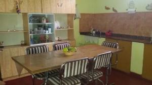a table in a kitchen with four chairs around it at El Chaparral Villa Dolores Traslasierra 2 in Piedra Pintada +9 photos