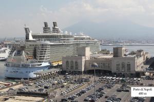 een cruiseschip is aangemeerd in een stad met auto's bij Santa Chiara Maison in Napels