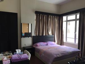 Un dormitorio con una cama con almohadas rosas y una ventana en STUDIO ROOM at BAYOULAGOON RESORT, MELAKA, en Melaka