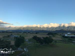 une vue sur un champ avec des montagnes en arrière-plan dans l'établissement Simple Life, à Yuli