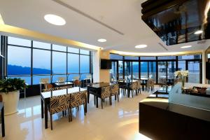 - une salle à manger avec des tables, des chaises et des fenêtres dans l'établissement Hu Yue Lakeview Hotel, à Yuchi