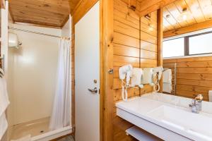 a bathroom with a white sink and a shower at Outrigger Motel in Paihia