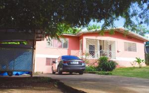 a car parked in front of a pink house at Fairmont in Negril