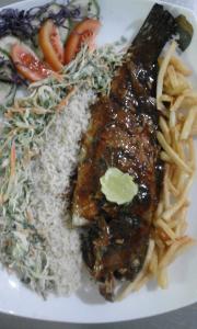 a plate of food with rice and meat and vegetables at Sihilro Regency in Udawalawe