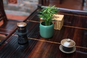 a table with a plant and two cups on it at Tam Coc Craft Homestay in Ninh Binh