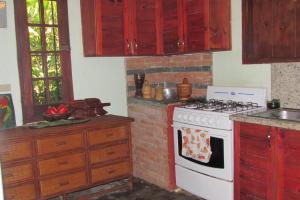 a kitchen with a white stove top oven next to a brick wall at Arroyo Frío River Lodge in Arroyo Frío