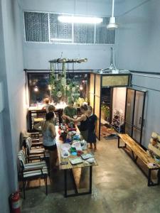 a group of people standing around a table in a room at Asleep Hostel in Kanchanaburi