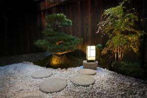 een lantaarn in een Japanse tuin 's nachts bij Hosta Umekoji Akari in Kyoto