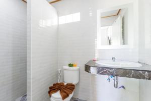 ein weißes Badezimmer mit Toilette und Waschbecken in der Unterkunft Lanta Coral Beach Resort in Ko Lanta