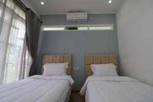 Кровать или кровати в номере Diyar Villas Puncak M6-11