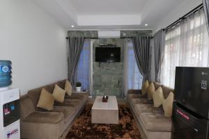 sala de estar con sofá y TV en Diyar Villas Puncak M6-11, en Puncak