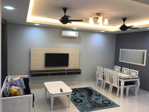 a living room with a tv and a table and chairs at ARA Muslim House @ Mutiara Heights Johor Bahru in Johor Bahru +18 photos