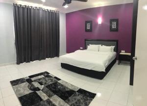 a bedroom with a bed with a purple wall at ARA Muslim House @ Mutiara Heights Johor Bahru in Johor Bahru