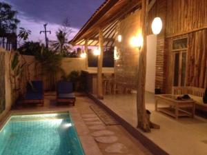 a swimming pool in front of a house at Villa Rika in Gili Trawangan