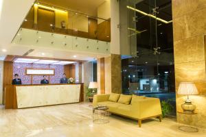 a lobby with a yellow couch and a bar at Classic Grande,a Member of Radisson in Imphal