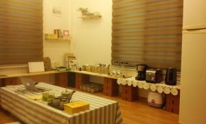 コジェにあるGeoje Ton Ton Guesthouseのカウンターとテーブル付きのキッチンが備わります。
