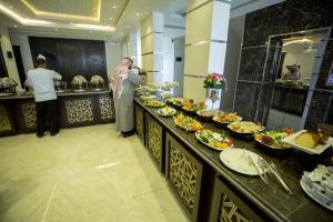 a man standing in front of a buffet of food at Rest Night Hotel Apartments Wadi Al Dawasir in Wadi Al Dawasir