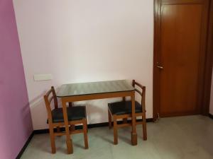 a table and two chairs and a table and a door at Comfort`s Pearl in Coimbatore