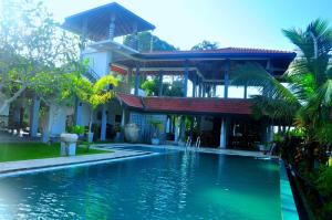 a swimming pool in front of a house at Jungle Heart Cabanas in Danwattegoda