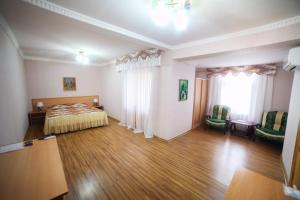 1 dormitorio con 1 cama y suelo de madera en Siyavush, en Bukhara