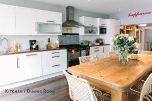 a kitchen with a wooden table and white cabinets at Cosy Home; Sleeps 10/11. City 15 minutes’ walk in Dublin