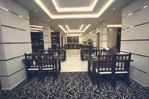 ein Restaurant mit Stühlen und Tischen in einem Zimmer in der Unterkunft Rest Night Hotel Apartments Wadi Al Dawasir in Wadi ad-Dawasir
