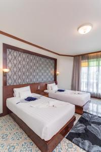 Postel nebo postele na pokoji v ubytování Erawan Hotel