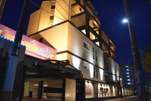 un edificio con un cartello sul lato di Hotel Coco de Sole & Coco de Mono(Love Hotel) a Oita