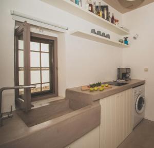 a kitchen with a counter with a window and a sink at Donusa Beach House - Etheras properties in Diakofti +6 photos