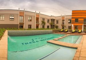 a swimming pool in front of a building at Peermont Metcourt - Thaba Moshate in Burgersfort